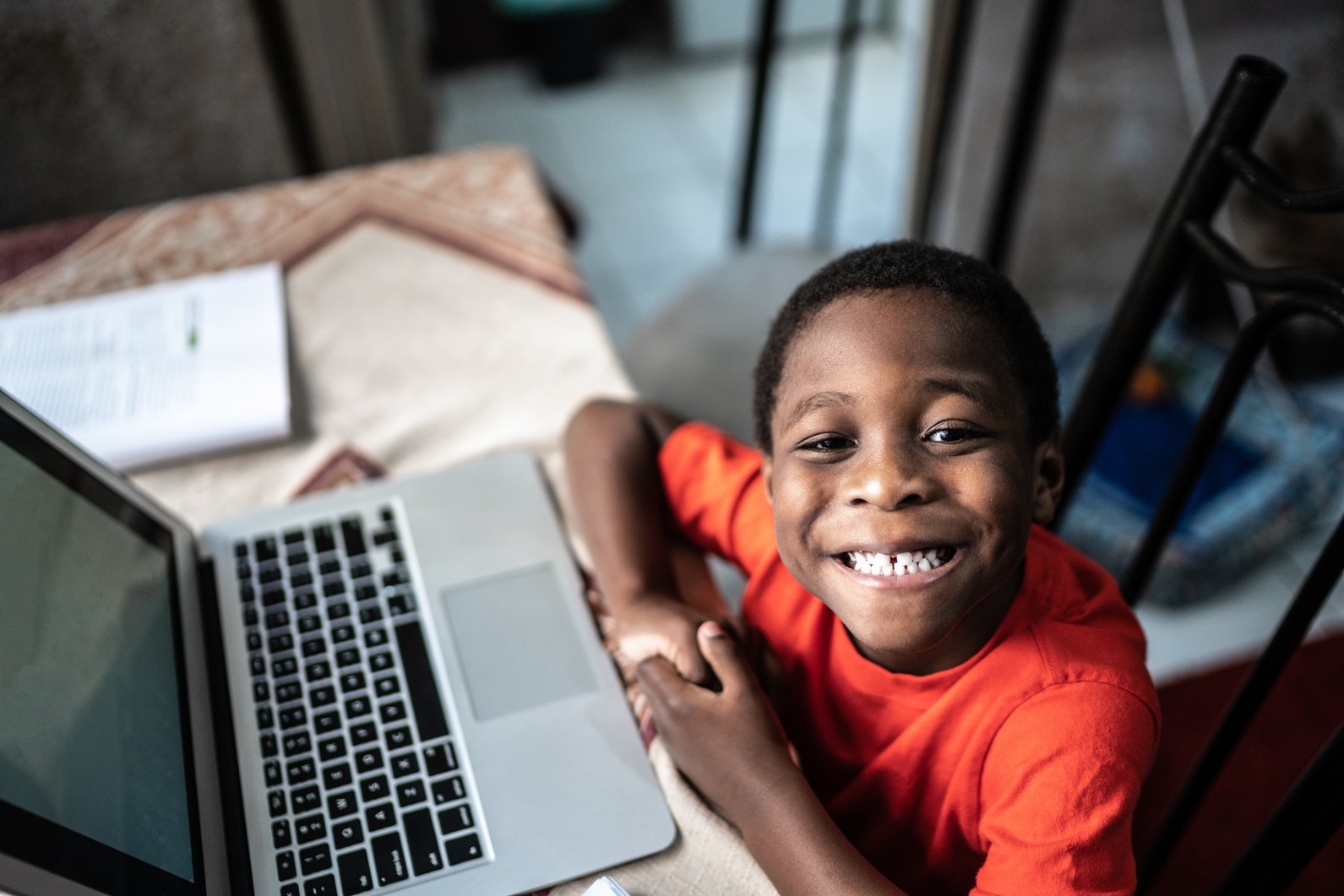 Portrait of a child with laptop on a online class at home