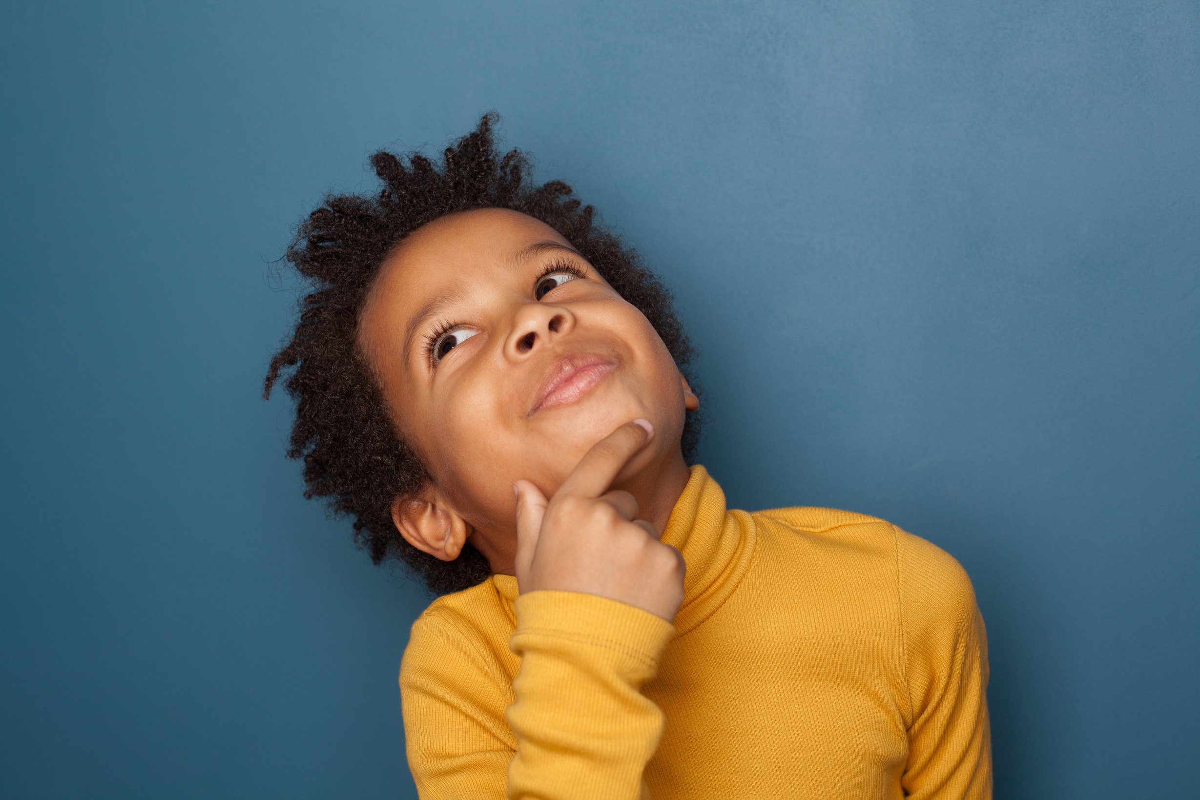 Little black child boy thinking on blue background